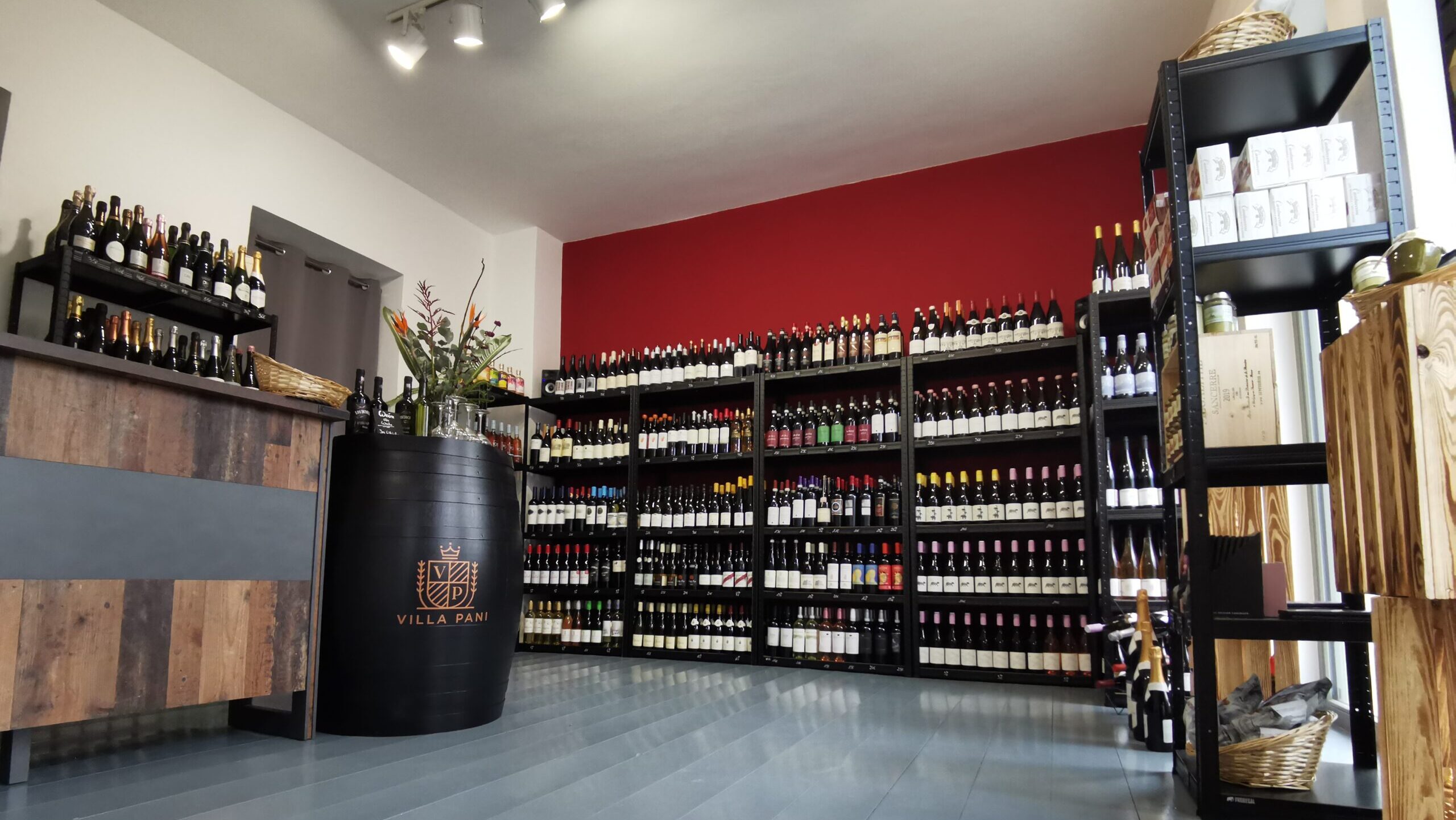 Innenansicht des Weinladens WEIN BUNNY in Berlin mit Weinregalen, Holztheke und Villa Pani Fass